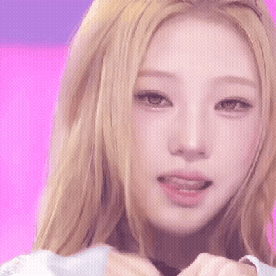 A Close Up Of A Woman 'S Face With A Pink Background . GIF