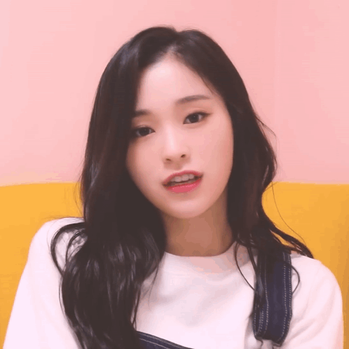 A Close Up Of A Woman 'S Face With A Pink Background GIF