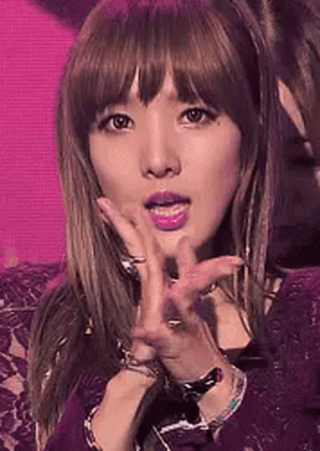 A Close Up Of A Woman 'S Face With A Pink Background . GIF