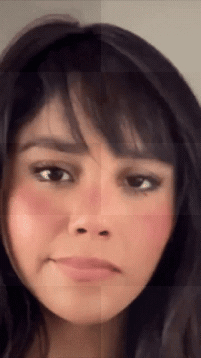 A Close Up Of A Woman 'S Face With A Pink Cheek GIF