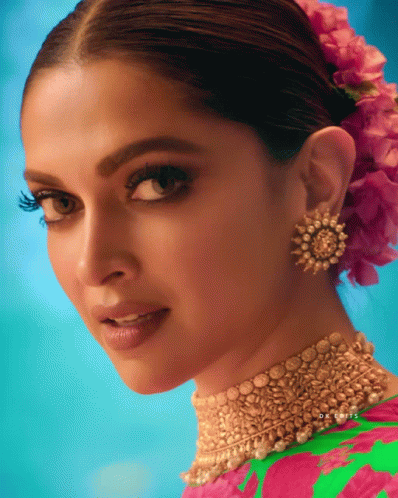 A Close Up Of A Woman 'S Face With A Pink Flower In Her Hair And The Name Dr. Louis On The Bottom GIF