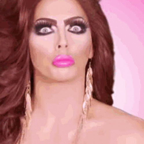 A Close Up Of A Woman 'S Face With A Pink Lip And Earrings . GIF