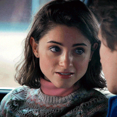 A Close Up Of A Woman 'S Face With A Pink Turtleneck GIF