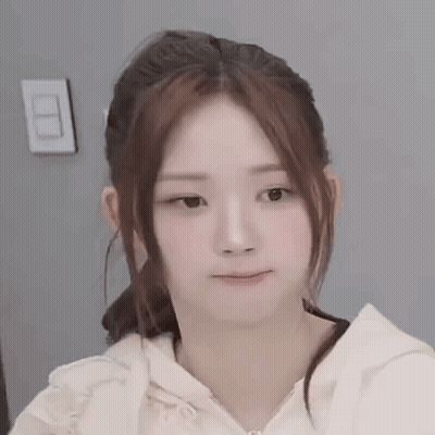 A Close Up Of A Woman 'S Face With A Ponytail And A Hoodie . GIF