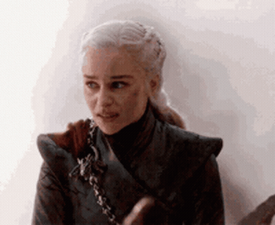A Close Up Of A Woman 'S Face With A Ponytail And A Sword In Her Hand . GIF