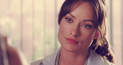 A Close Up Of A Woman 'S Face With A Ponytail And Blue Eyes GIF