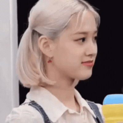A Close Up Of A Woman 'S Face With A Ponytail And Earrings . GIF
