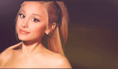 A Close Up Of A Woman 'S Face With A Ponytail And Earrings GIF