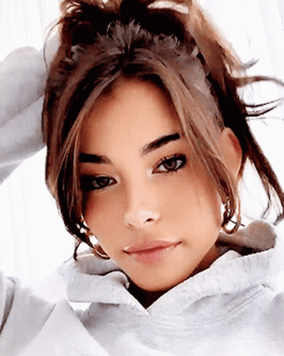 A Close Up Of A Woman 'S Face With A Ponytail GIF