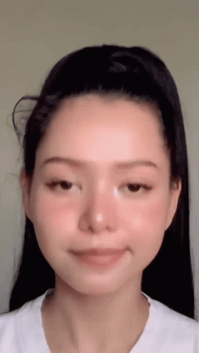 A Close Up Of A Woman 'S Face With A Ponytail . GIF