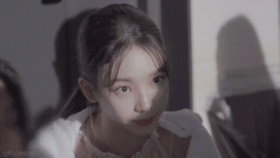 A Close Up Of A Woman 'S Face With A Ponytail Looking At The Camera . GIF