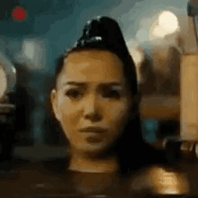 A Close Up Of A Woman 'S Face With A Ponytail On Her Head . GIF