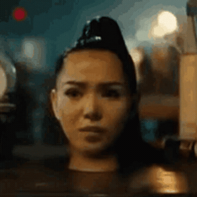 A Close Up Of A Woman 'S Face With A Ponytail . GIF