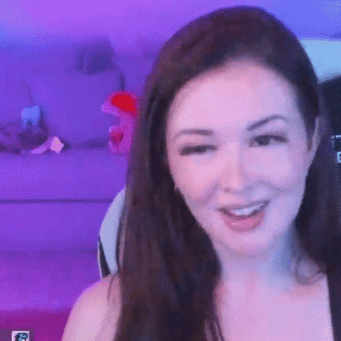 A Close Up Of A Woman 'S Face With A Purple Background . GIF
