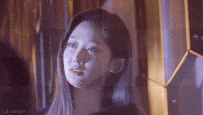A Close Up Of A Woman 'S Face With A Purple Background GIF