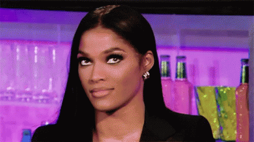 A Close Up Of A Woman 'S Face With A Purple Background . GIF