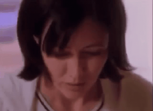 A Close Up Of A Woman 'S Face With A Purple Background . GIF