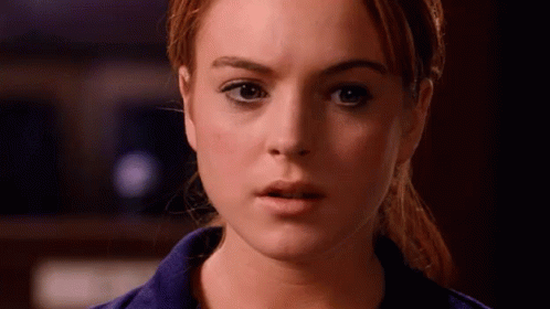 A Close Up Of A Woman 'S Face With A Purple Shirt On . GIF