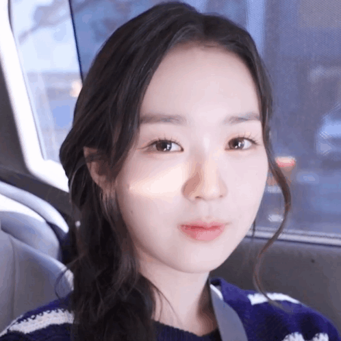 A Close Up Of A Woman 'S Face With A Purple Sweater On GIF