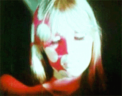 A Close Up Of A Woman 'S Face With A Red And White Floral Pattern On It GIF