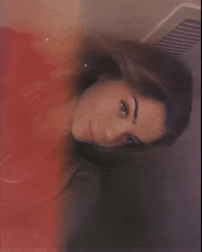 A Close Up Of A Woman 'S Face With A Red And Yellow Background GIF