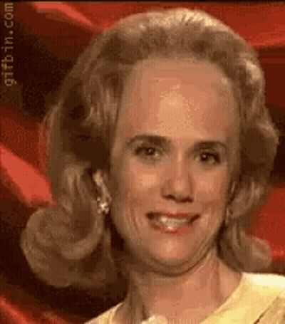 A Close Up Of A Woman 'S Face With A Red Background And A Yellow Shirt . GIF