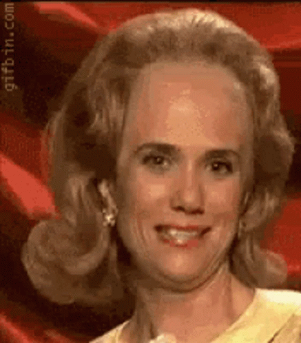A Close Up Of A Woman 'S Face With A Red Background And A Yellow Shirt . GIF
