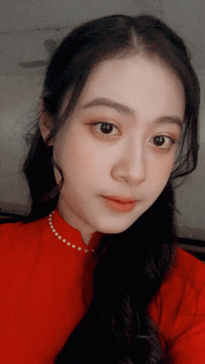 A Close Up Of A Woman 'S Face With A Red Shirt On GIF