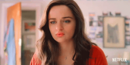 A Close Up Of A Woman 'S Face With A Red Sweater And Necklace . GIF