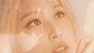 a close up of a woman 's face with a reflection of the sun on her face .