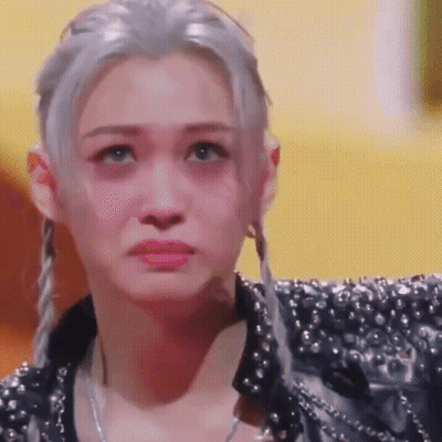A Close Up Of A Woman 'S Face With A Sad Look On Her Face . GIF