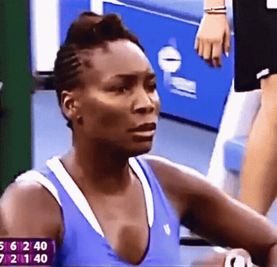 A Close Up Of A Woman 'S Face With A Scoreboard In The Background GIF