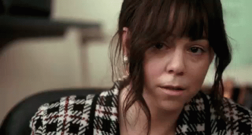 A Close Up Of A Woman 'S Face With A Serious Look On Her Face . GIF