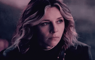 A Close Up Of A Woman 'S Face With A Serious Look On Her Face In A Dark Room . GIF