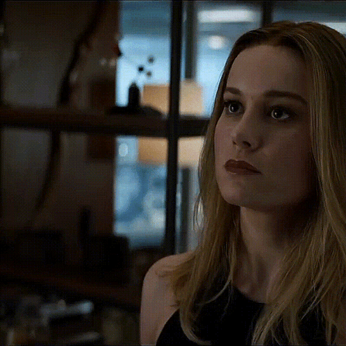 A Close Up Of A Woman 'S Face With A Serious Look On Her Face In A Dark Room . GIF