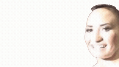 A Close Up Of A Woman 'S Face With A Shaved Head Smiling . GIF
