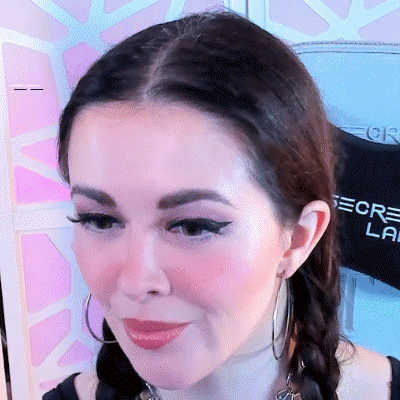 A Close Up Of A Woman 'S Face With A Shirt Behind Her That Says Secret Lab GIF