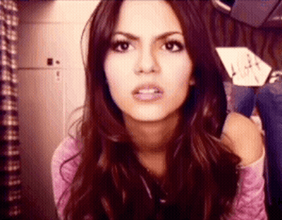 A Close Up Of A Woman 'S Face With A Sign In The Background That Says " Alight " GIF