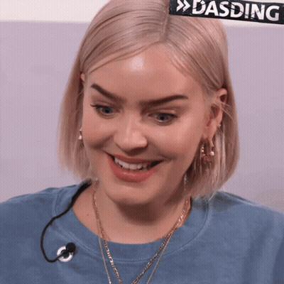 A Close Up Of A Woman 'S Face With A Sign That Says Dasding Behind Her GIF