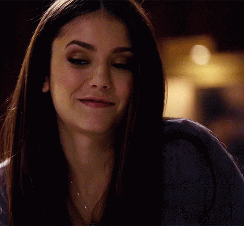A Close Up Of A Woman 'S Face With A Slight Smile On Her Face GIF