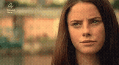 A Close Up Of A Woman 'S Face With A Slight Smile On Her Face . GIF