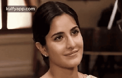 A Close Up Of A Woman 'S Face With A Slight Smile On Her Face . GIF