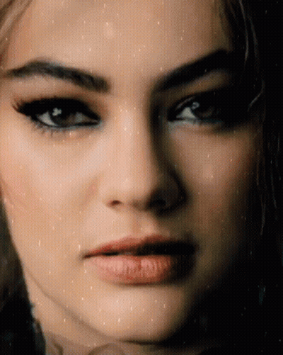 A Close Up Of A Woman 'S Face With A Slight Smile On Her Face GIF