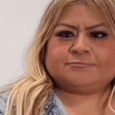 A Close Up Of A Woman 'S Face With A Slight Smirk On Her Face GIF