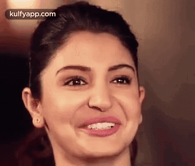 A Close Up Of A Woman 'S Face With A Smile . GIF