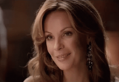 A Close Up Of A Woman 'S Face With A Smile On Her Face . GIF