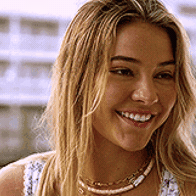 A Close Up Of A Woman 'S Face With A Smile On Her Face . GIF