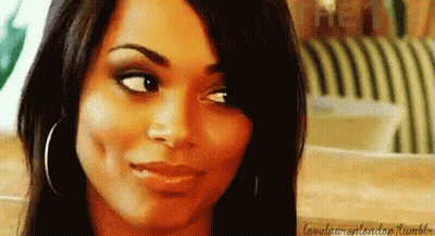 A Close Up Of A Woman 'S Face With A Smile On Her Face And A Striped Chair In The Background . GIF