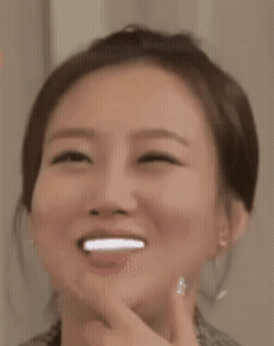A Close Up Of A Woman 'S Face With A Smile On Her Face . GIF
