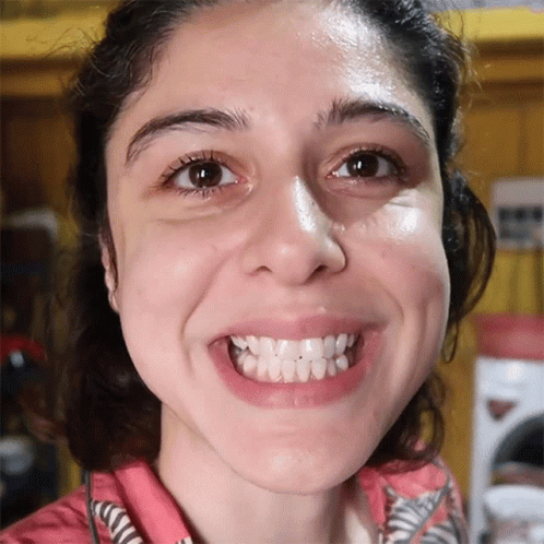 A Close Up Of A Woman 'S Face With A Smile On It GIF